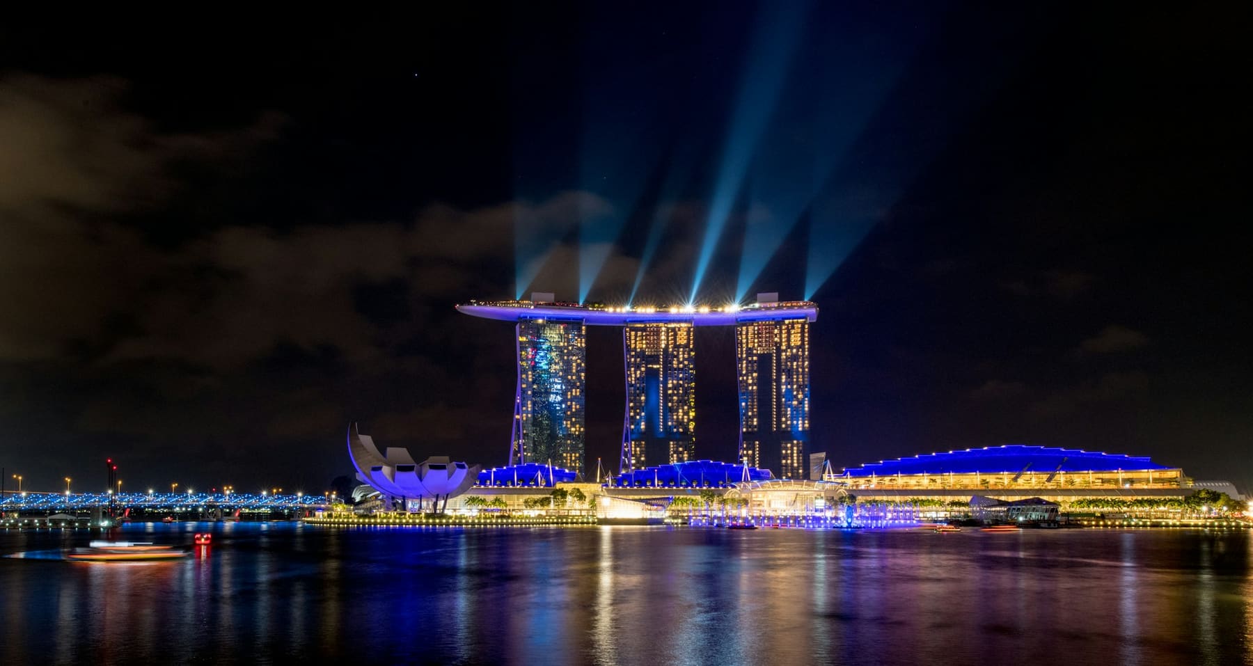Marina Bay Sands lit up at night, reflected in Marina Bay, seen from Jubilee Bridge